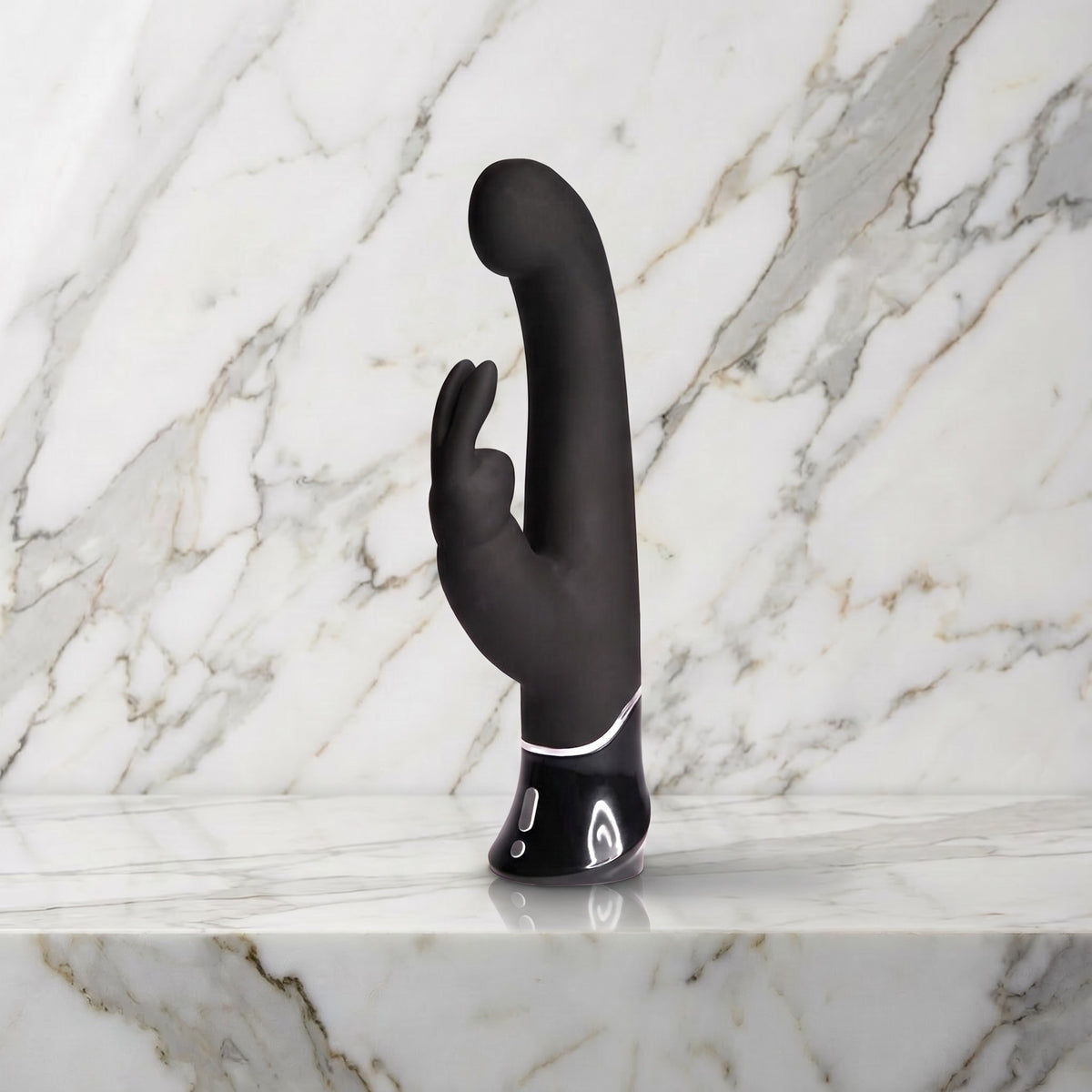 Zwarte Greedy Girl rabbit vibrator met gebogen kop en oortjes rechtop op een marmeren plank