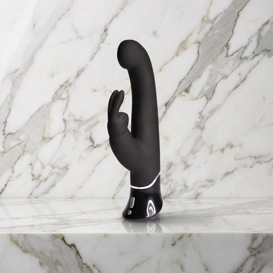 Zwarte Greedy Girl rabbit vibrator met gebogen kop en oortjes rechtop op een marmeren plank