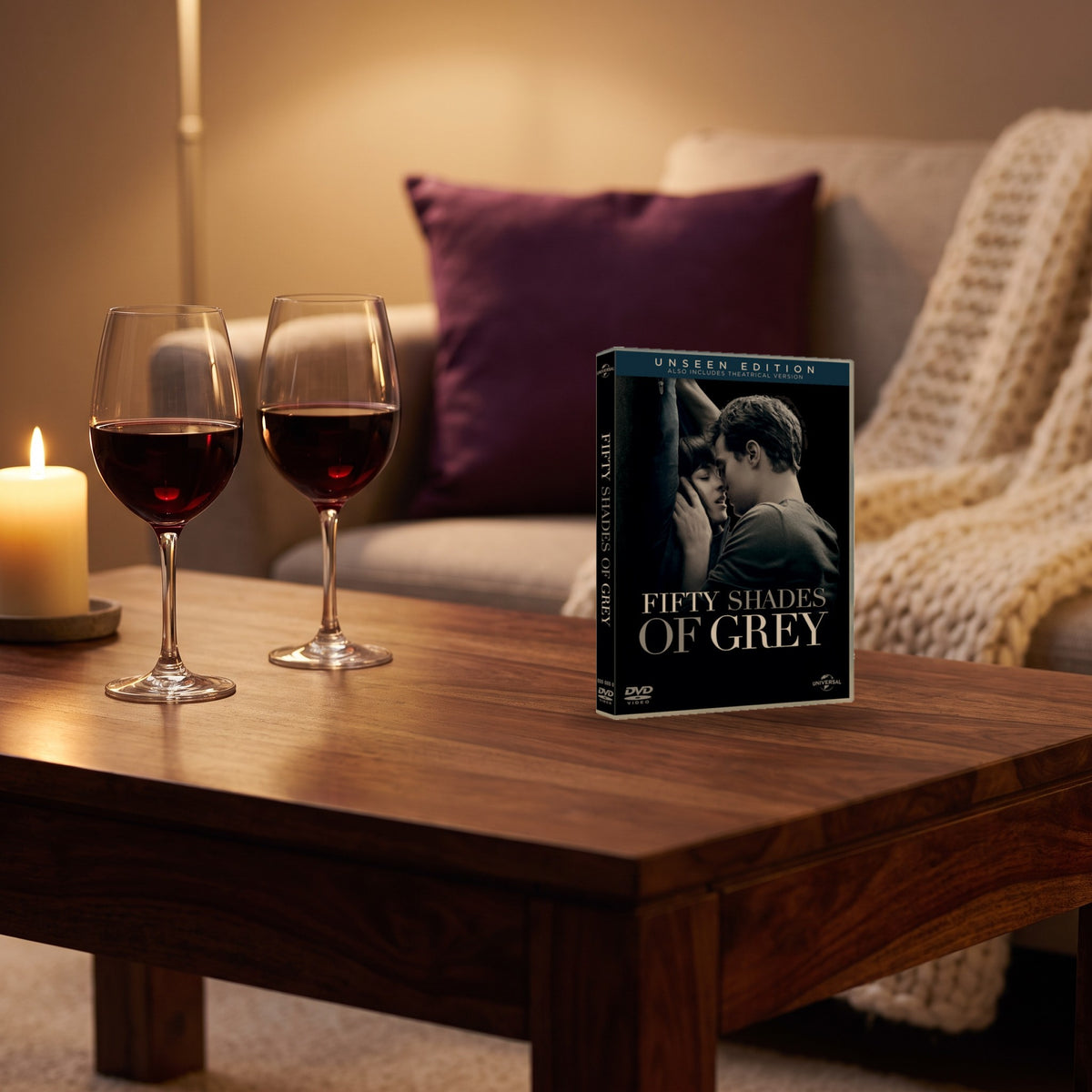 Sfeerbeeld: dvd Fifty Shades of Grey op een salontafel met twee glazen rode wijn en een kaars