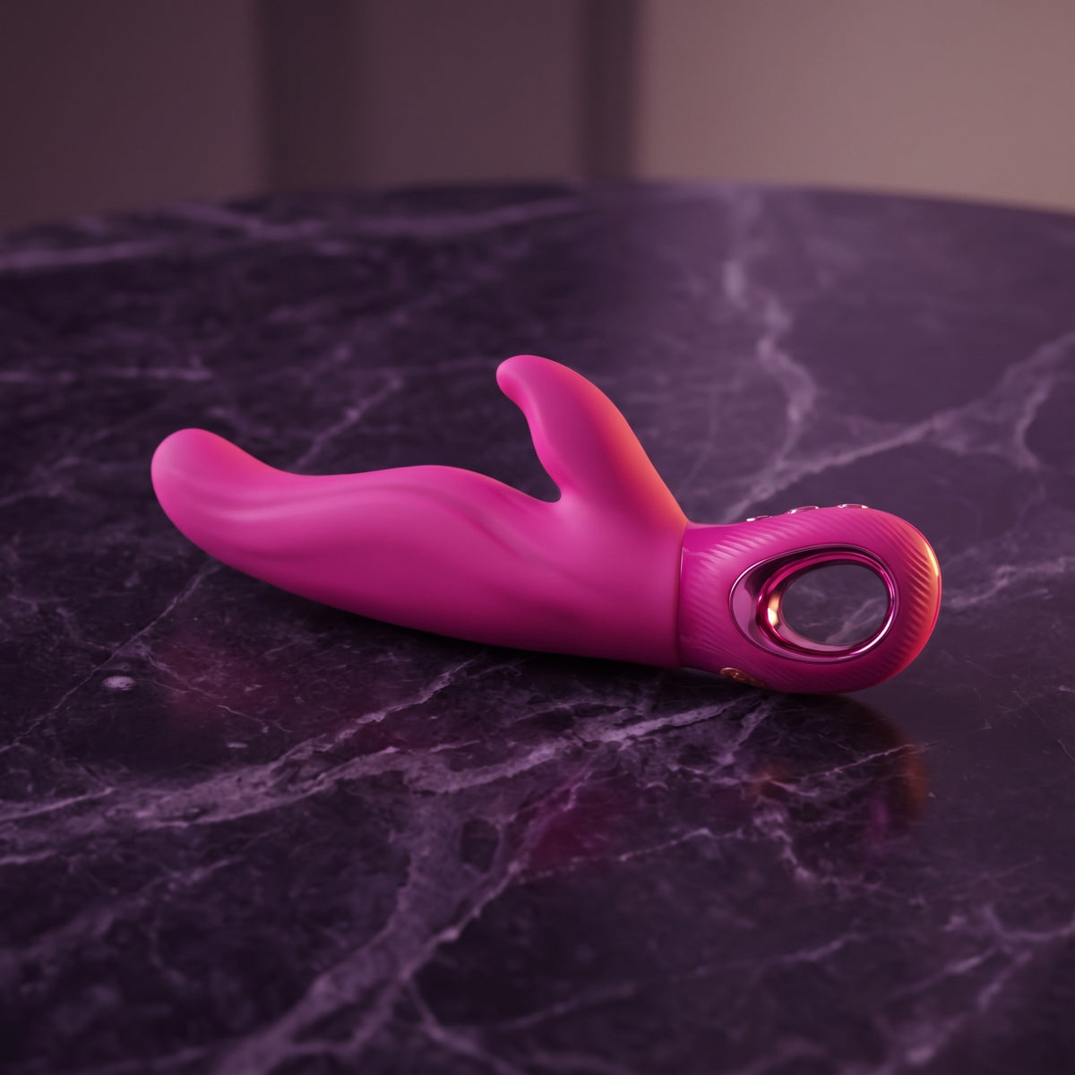 Sfeerbeeld: neonroze Lady Bi rabbit vibrator op donkerpaars marmer in gedempt licht