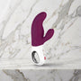 Bordeauxrode Fun Factory Miss Bi rabbit vibrator rechtop op een marmeren plank