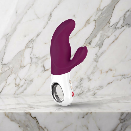 Bordeauxrode Fun Factory Miss Bi rabbit vibrator rechtop op een marmeren plank