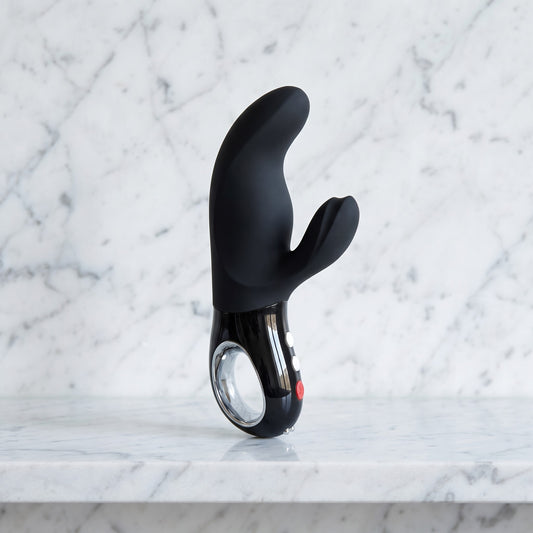 Zwarte Fun Factory Miss Bi rabbit vibrator rechtop op een marmeren plank