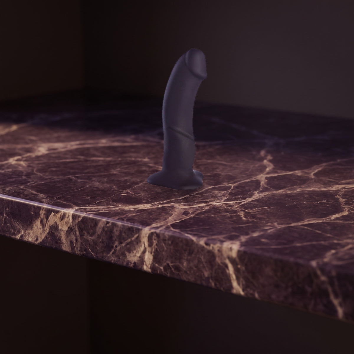 Sfeerbeeld: zwarte dildo The Boss rechtop op donkerpaars marmer in gedempt licht