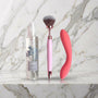 Gentle Sensations Kit op een marmeren plank: fles Hydra+ glijmiddel, roze vibrerende brush en koraalroze slanke vibrator