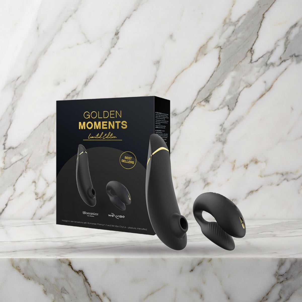 Golden Moments doos met de Womanizer Premium 2 en de We-Vibe Chorus op een marmeren plank