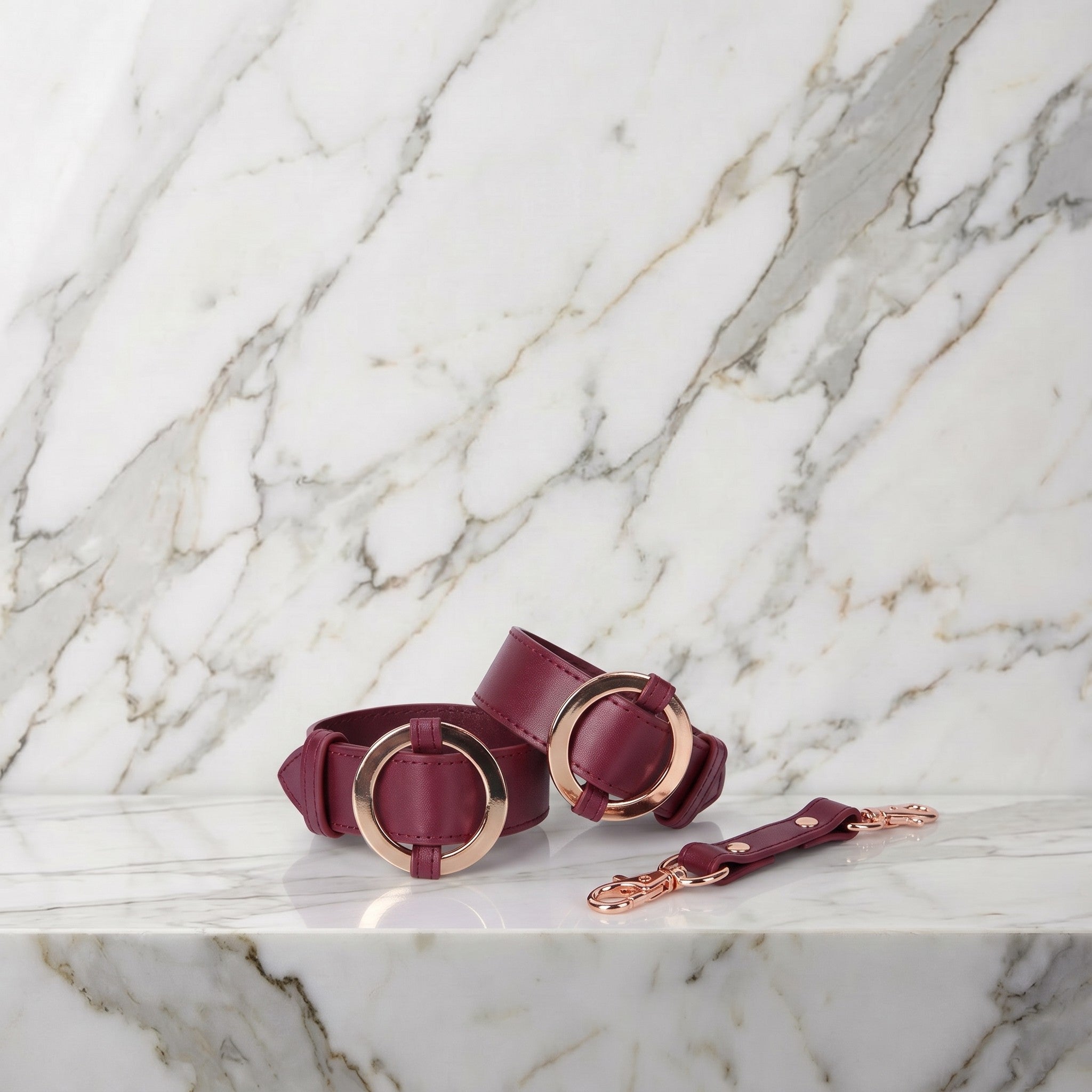 Twee bordeauxrode boeien met goudkleurige ringen op een marmeren plank