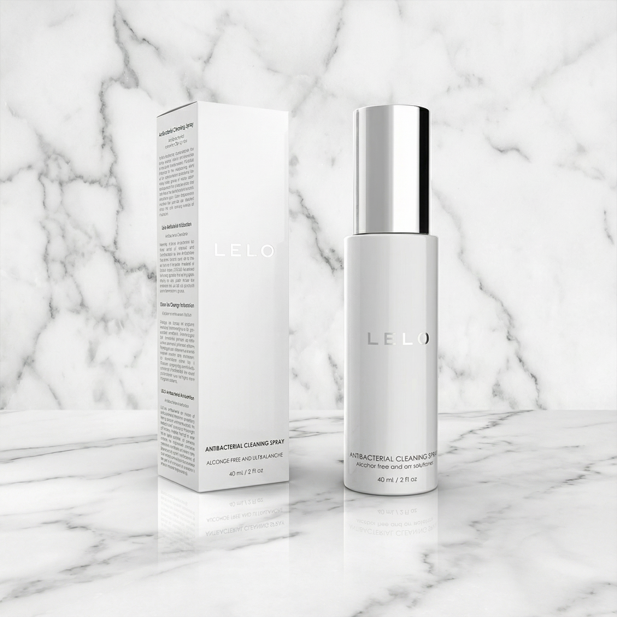 Witte Lelo reinigingsspray met zilveren dop naast de doos op een marmeren plank