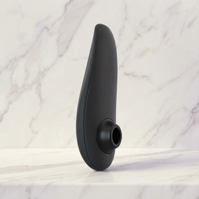 Zwarte luchtdrukvibrator staand op een marmeren plank, Womanizer Classic 2 in zwart