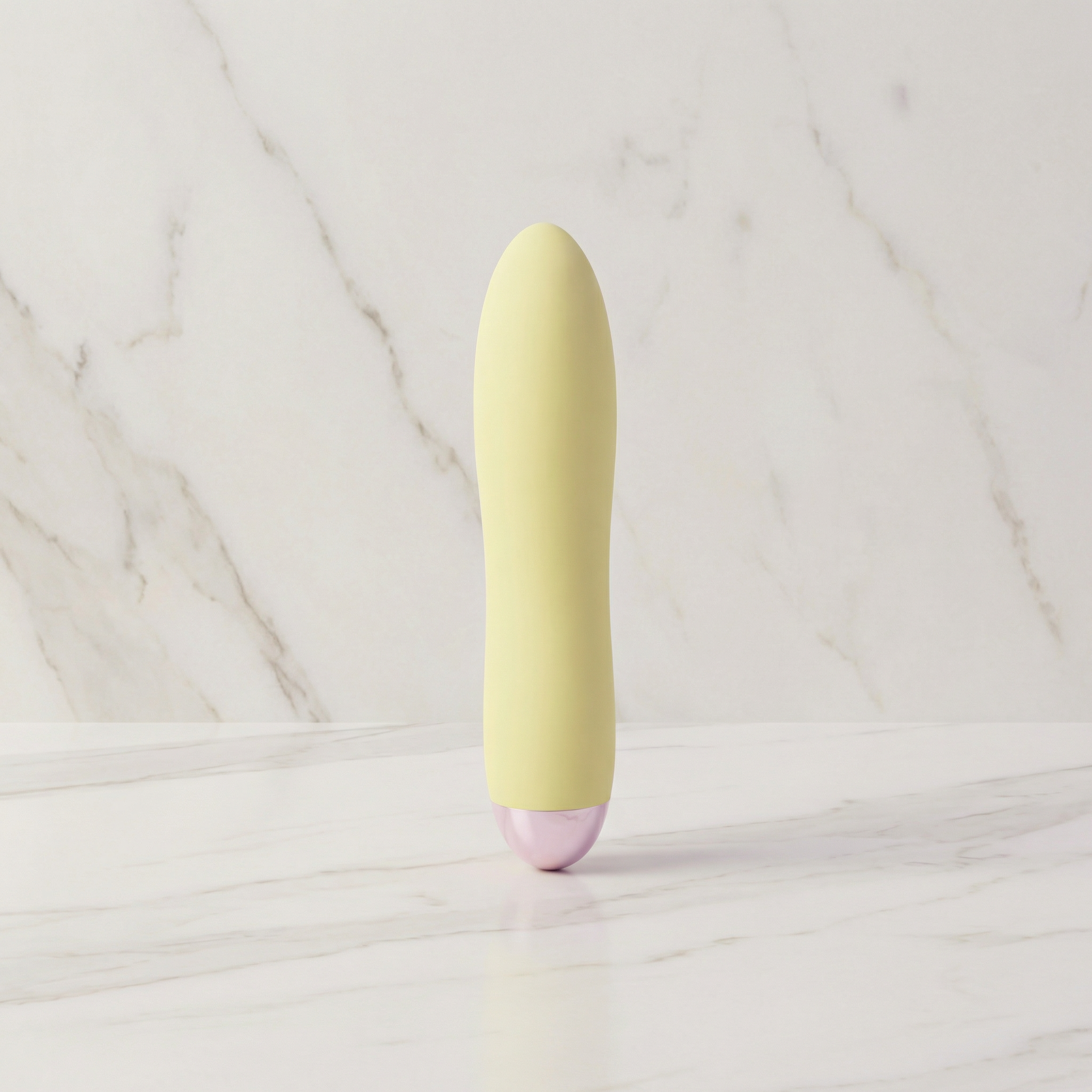 Lichtgele Cuties mini vibrator rechtop op een marmeren plank