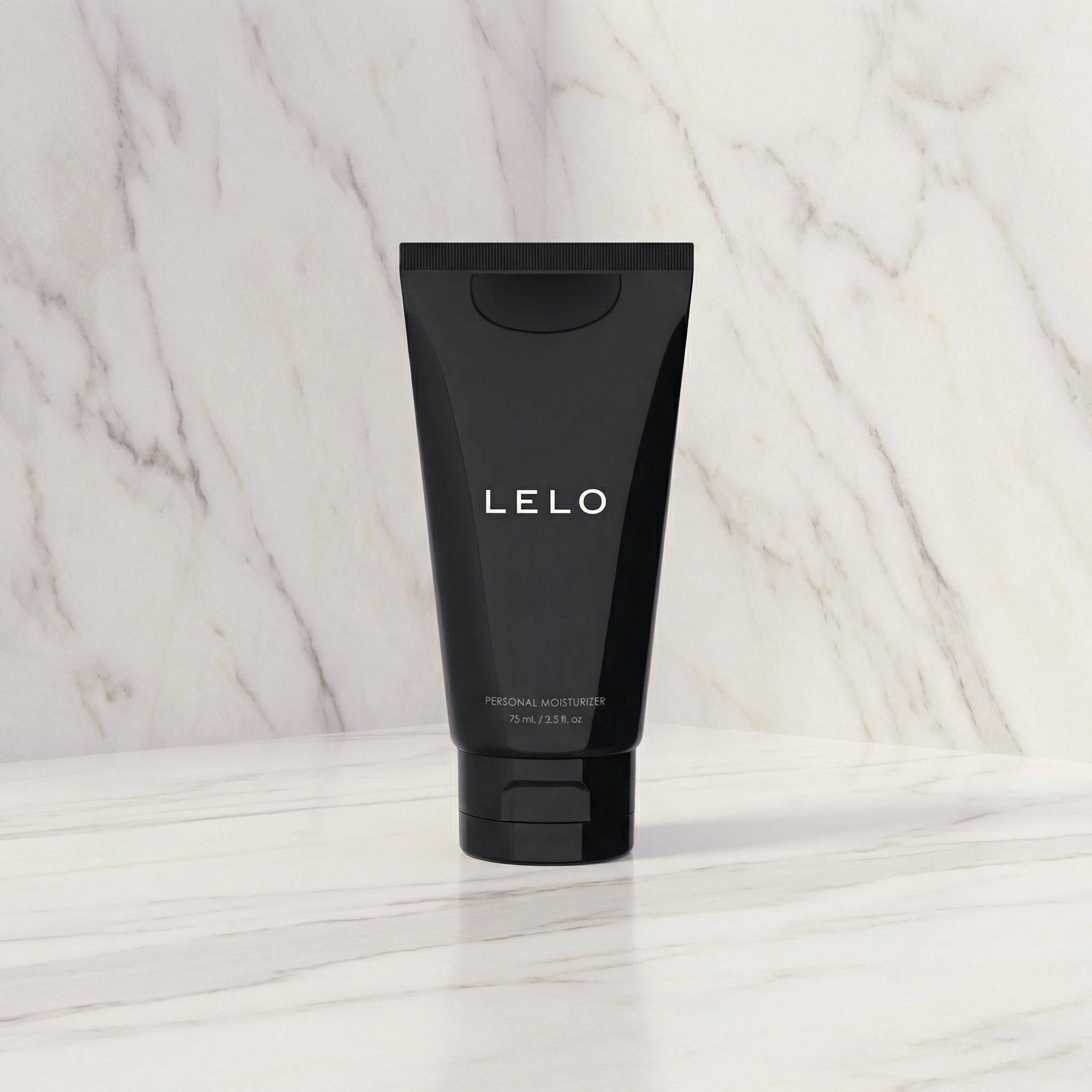 Zwarte tube LELO Personal Moisturizer 75 ml op een marmeren plank