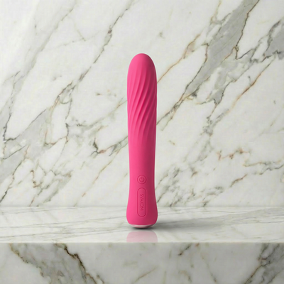 Roze Svakom Anya staafvibrator met ribbels rechtop op een marmeren plank