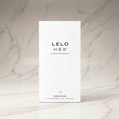 Witte doos HEX Original condooms met 12 stuks op een marmeren plank, LELO