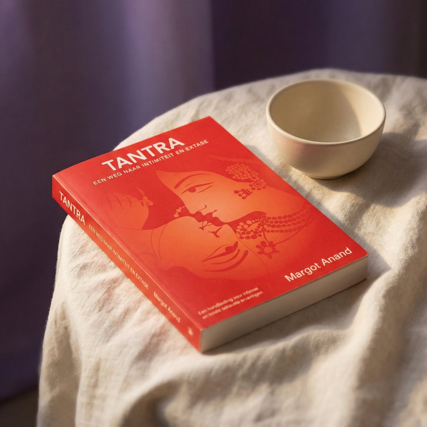 Tantra boek van Margot Anand op linnen doek met keramisch schaaltje in warme sfeer