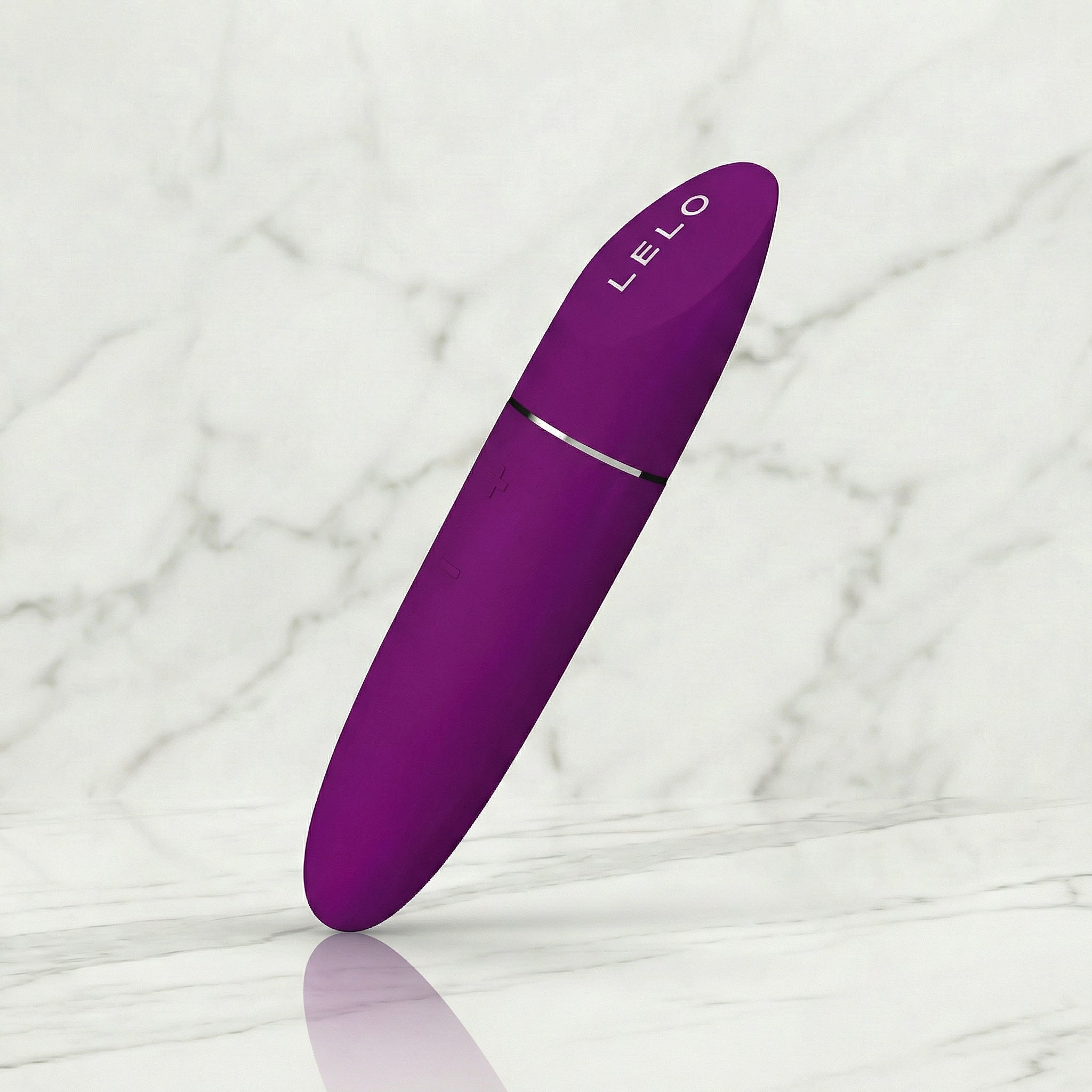 Fuchsia roze Lelo Mia 3 lippenstift vibrator schuin rechtop op een marmeren plank