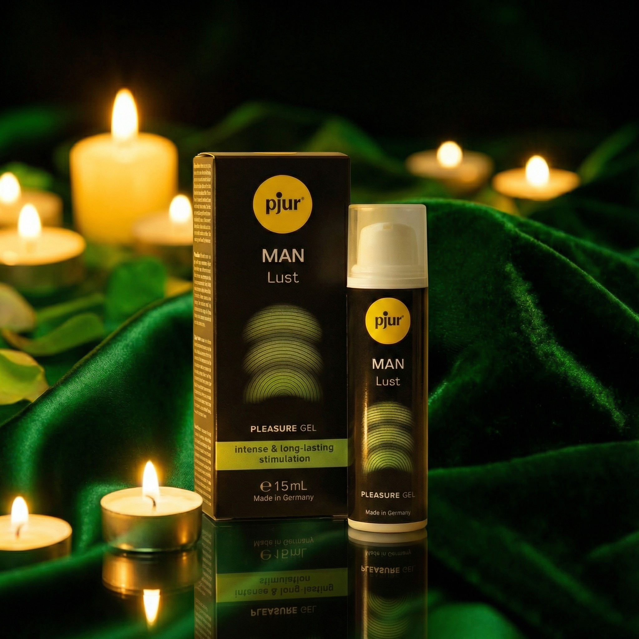 Pjur MAN Lust serum met sfeervol kaarslicht op donkergroen fluweel, zwarte doos en wit pompflesje