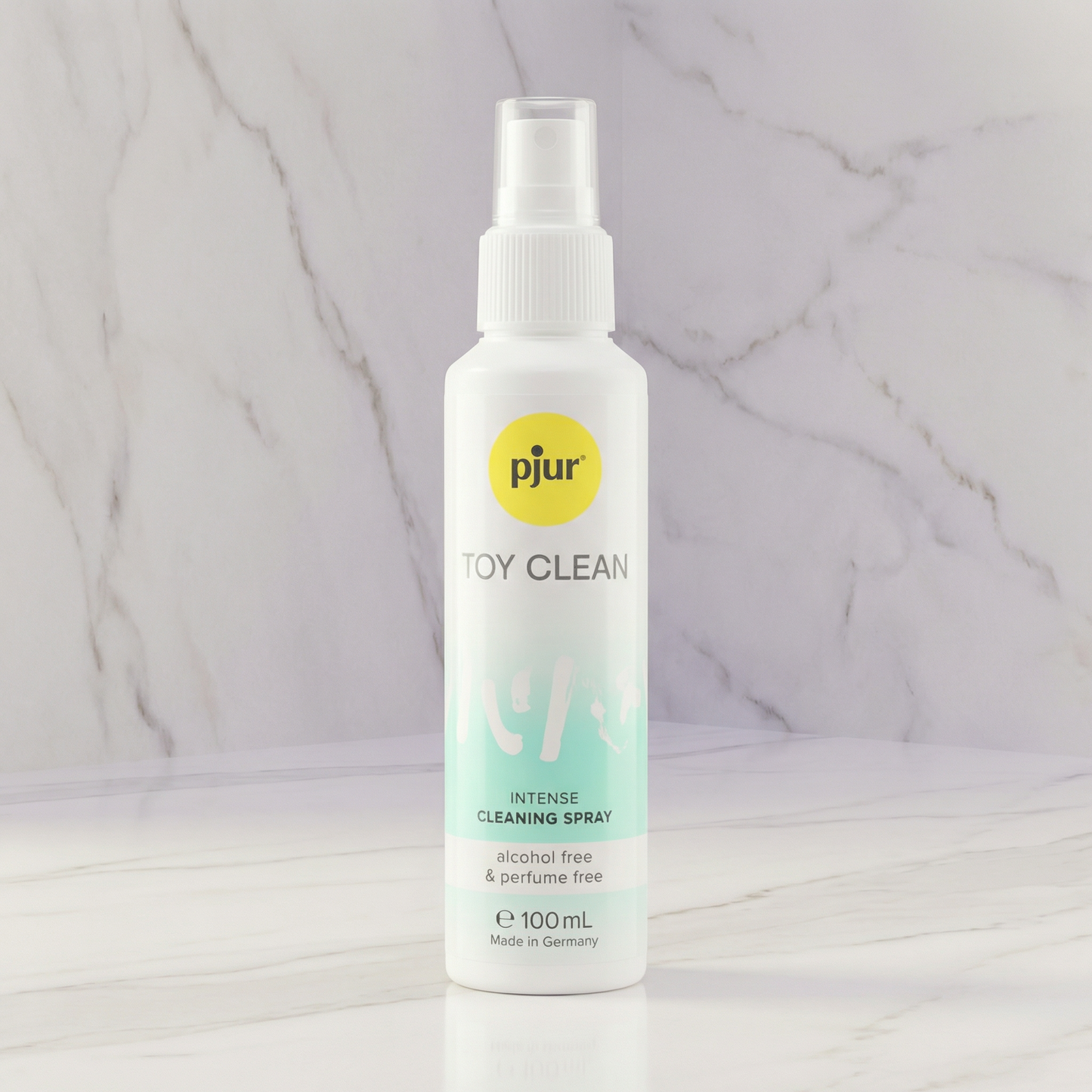 Witte sprayflacon pjur Toy Clean reinigingsspray 100 ml op marmeren plank tegen marmeren achtergrond