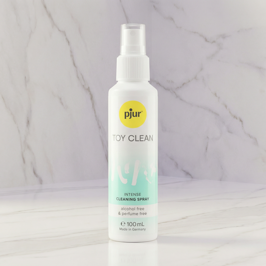 Witte sprayflacon pjur Toy Clean reinigingsspray 100 ml op marmeren plank tegen marmeren achtergrond