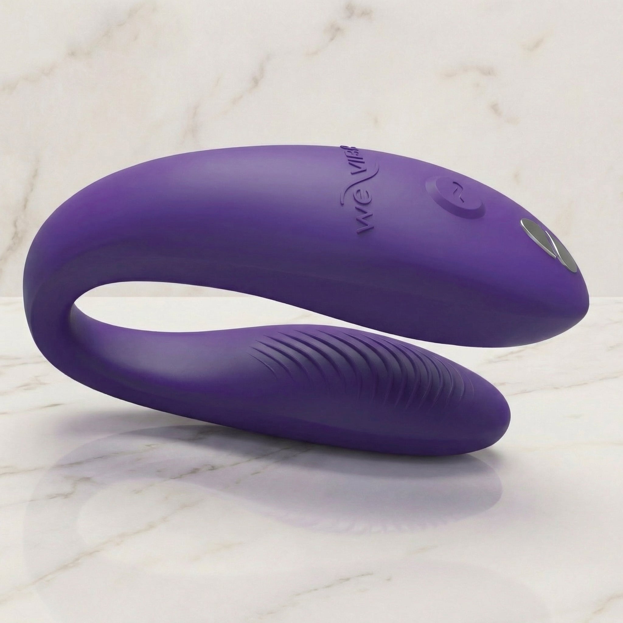 Paarse We-Vibe Sync Go koppelvibrator liggend op een lichte marmeren plank