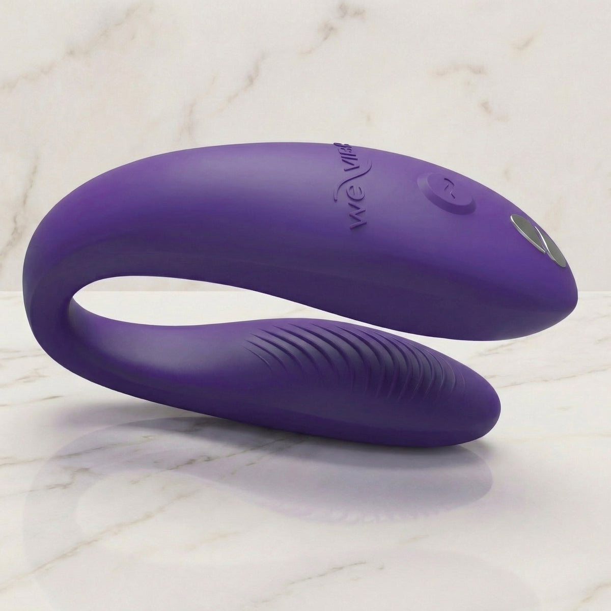 Paarse We-Vibe Sync Go koppelvibrator liggend op een lichte marmeren plank