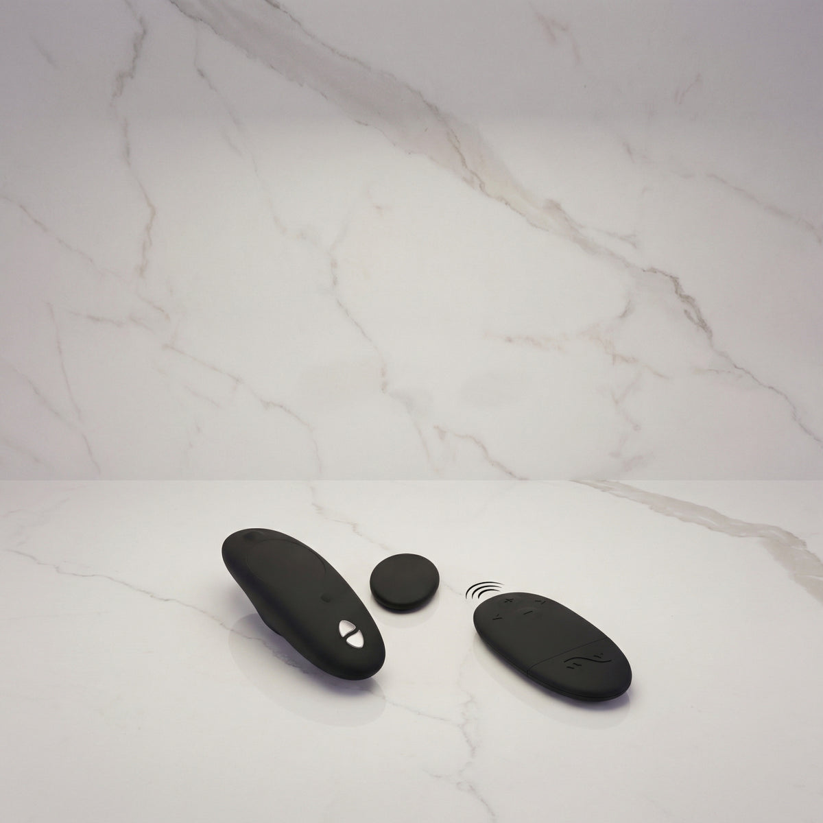 Zwarte We-Vibe Moxie+ met magneet en afstandsbediening op een marmeren plank