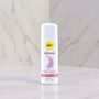 Pjur Woman siliconen glijmiddel 30 ml, witte fles met roze accent, op marmeren achtergrond