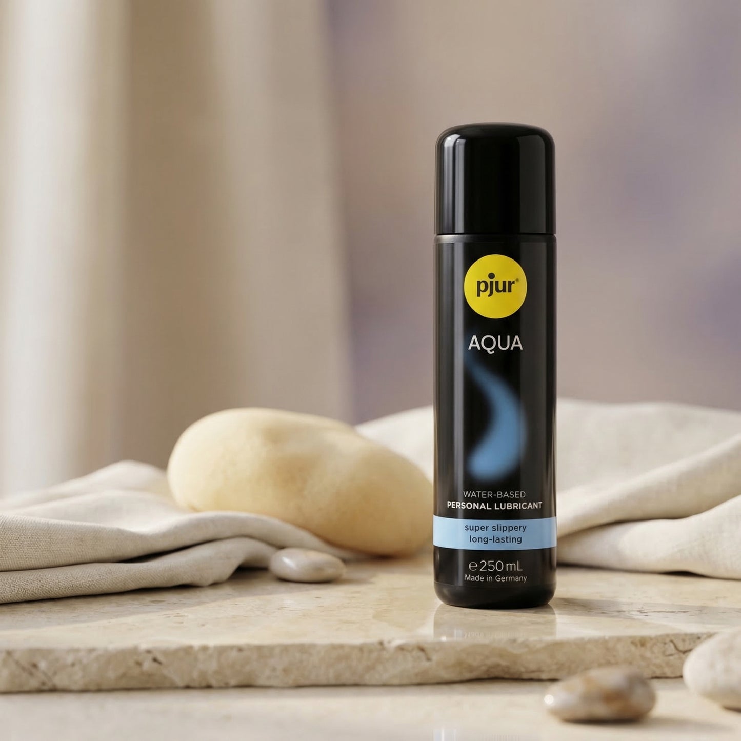Pjur Aqua waterbasis glijmiddel 250 ml in sfeerfoto met stenen en linnen doek