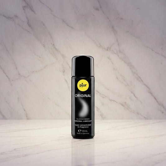 Pjur Original siliconenbasis glijmiddel 30 ml reisformaat, zwarte fles tegen marmeren achtergrond