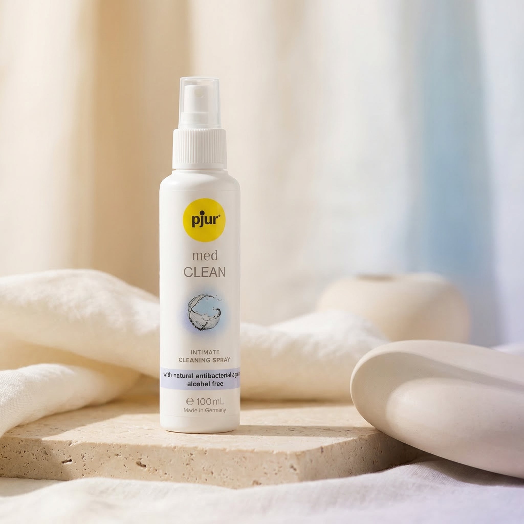 Pjur Med Clean intieme reinigingsspray 100 ml, witte sprayfles op natuurstenen ondergrond