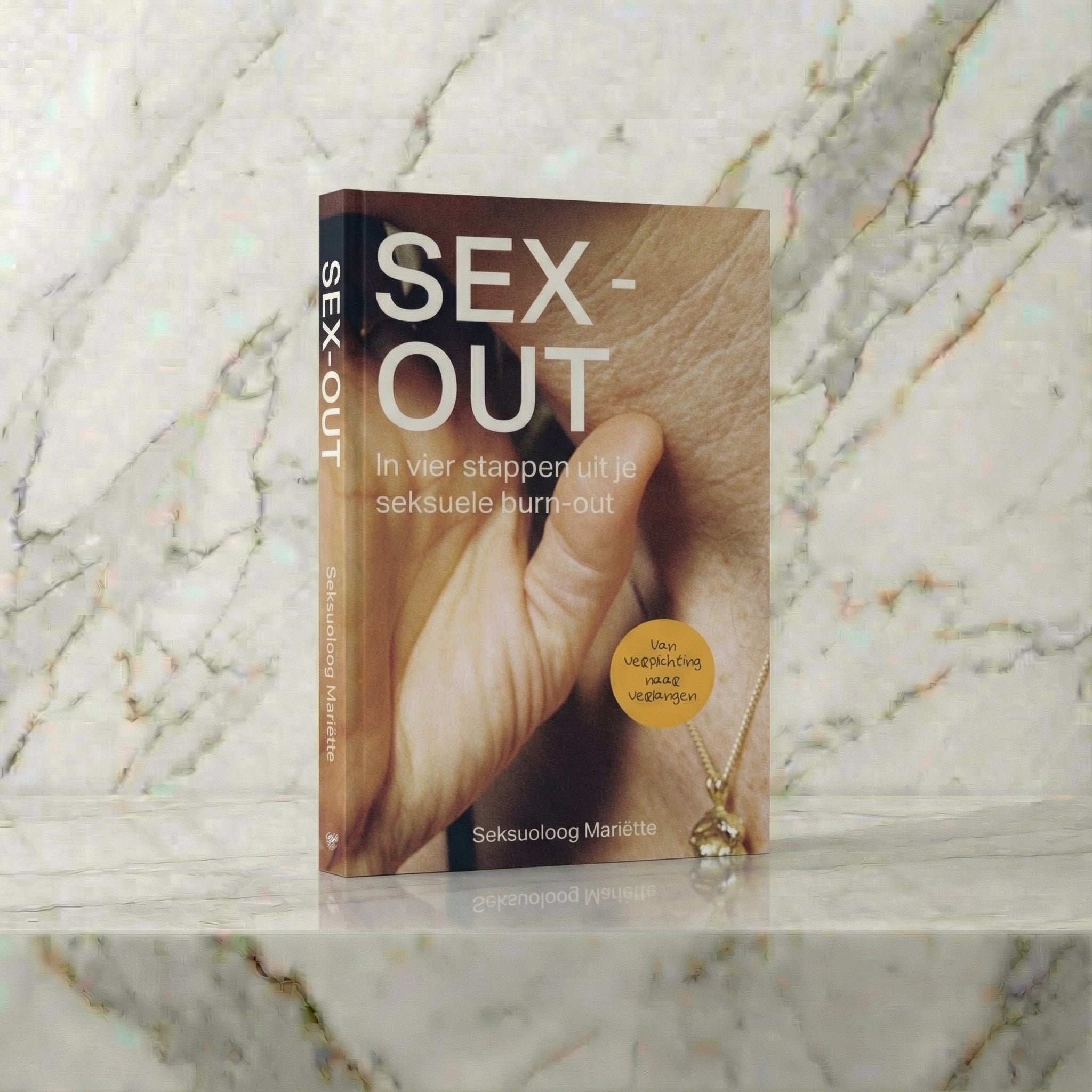 Boek Sex-out rechtop op een marmeren plank, van seksuoloog Mariëtte Sinninghe Damsté