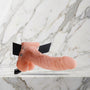 Nude holle strap-on met balzak en zwarte heupband op een marmeren plank