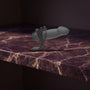 Sfeerbeeld: zwarte holle strap-on op donkerpaars marmer in gedempt licht, Body Extensions