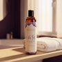 Sfeerbeeld: fles Intimate Earth Ease rechtop op een badkamerplank naast een witte handdoek