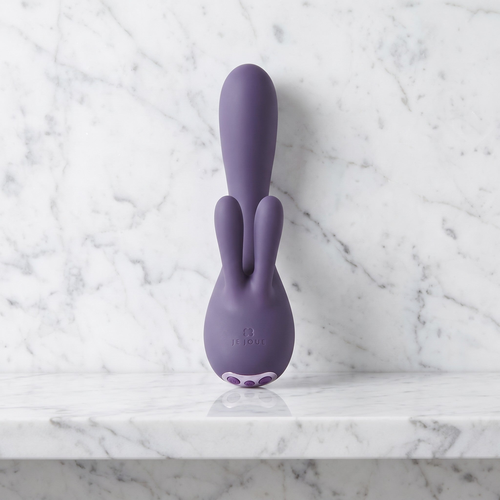 Paarse rabbit vibrator met twee oortjes rechtop op een marmeren plank, Je Joue Fifi