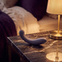 Sfeerbeeld: paarse G-Kii g-spot vibrator op een donker nachtkastje bij warm lamplicht