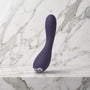 Paarse gebogen vibrator rechtop op een marmeren plank, Je Joue Uma