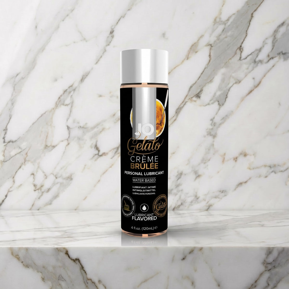 Zwarte fles JO Gelato Crème Brûlée glijmiddel met zilveren dop op een marmeren plank