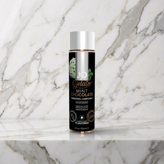 Fles glijmiddel met zwart label en zilveren dop op een marmeren plank, JO Gelato Mint Chocolate
