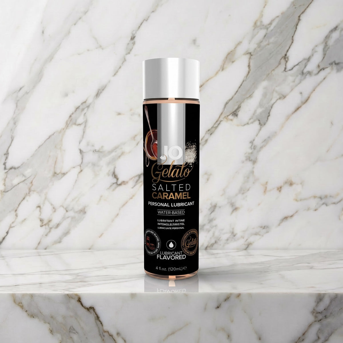 Zwarte fles JO Gelato Salted Caramel glijmiddel met zilveren dop op een marmeren plank