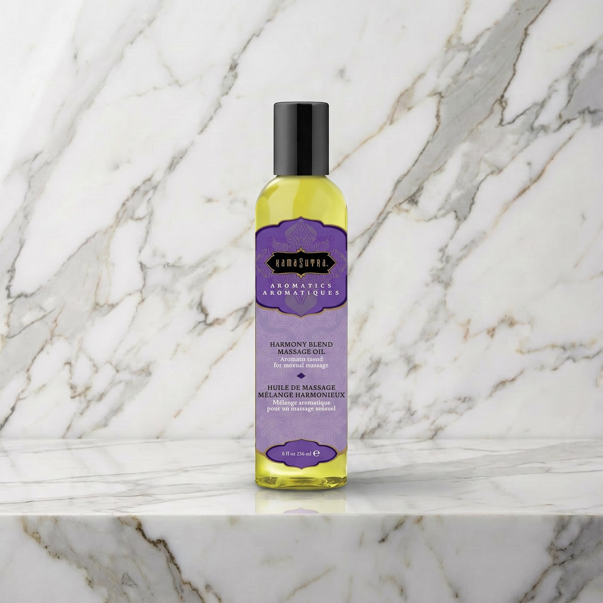 Fles Harmony Blend massageolie met paars etiket op een marmeren plank, Kama Sutra