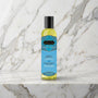 Fles massageolie met turquoise etiket op een marmeren plank, Kamasutra Serenity