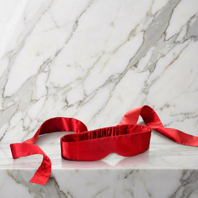 Rode zijden blinddoek met twee lange linten op een marmeren plank, Lelo Intima Silk