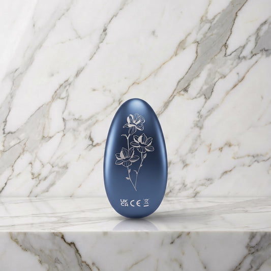 Donkerblauwe LELO Nea 3 clitorisvibrator met bloemengravure op een marmeren plank
