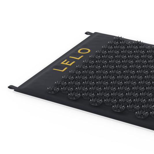 Rand van de zwarte mat met gouden logo en twee lusjes, LELO Relax Body Mat