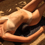 Vrouw ligt op de spijkermat met het kussen onder haar onderrug, LELO Relax Body Mat