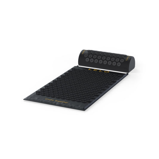 Zwarte acupressuurmat met kussen vanaf een lage hoek, Relax Body Mat van LELO