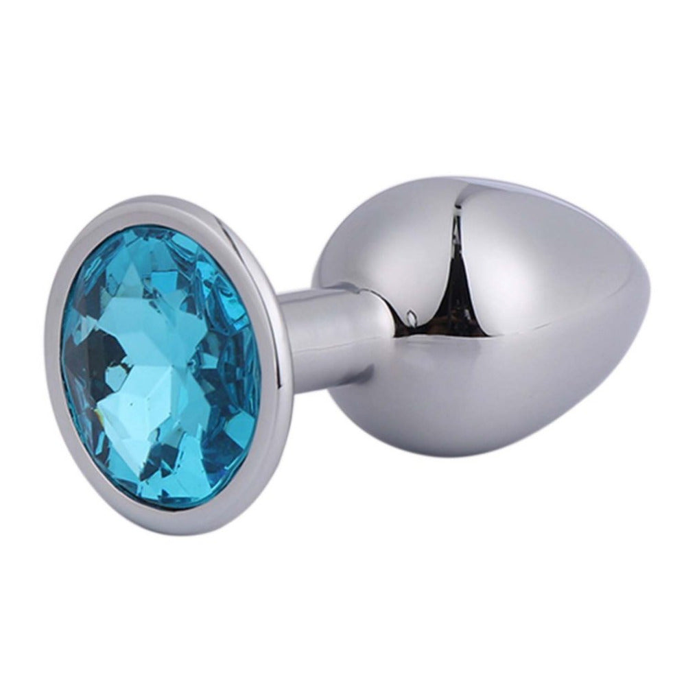Zilverkleurige metalen buttplug met lichtblauwe siersteen aan de basis op witte achtergrond