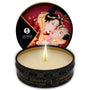 Open blikje met brandende kaars en rood deksel met prent, Shunga massagekaars Sparkling Strawberry
