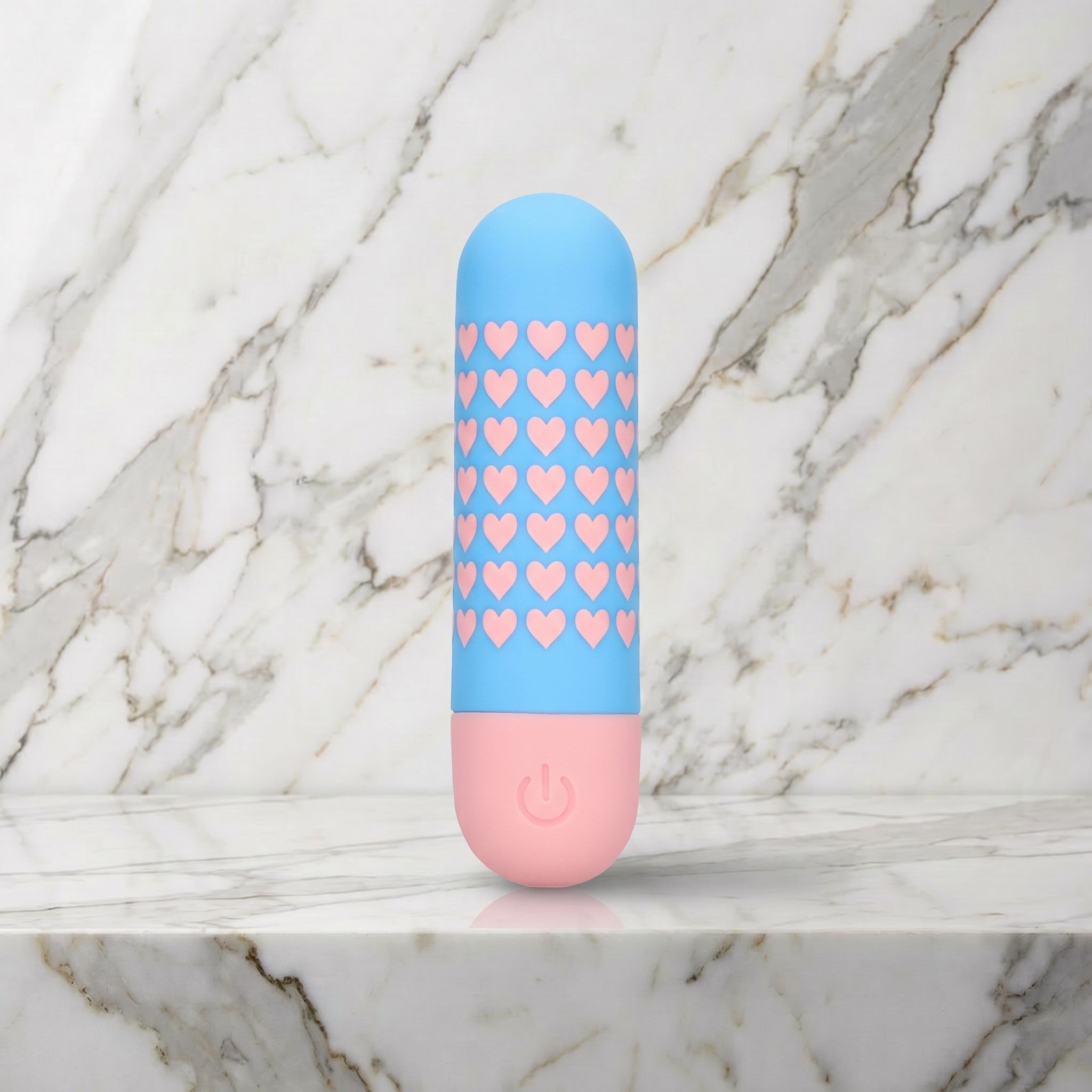 Lichtblauwe bullet vibrator met roze hartjes rechtop op een marmeren plank, Mini vibrator Heart