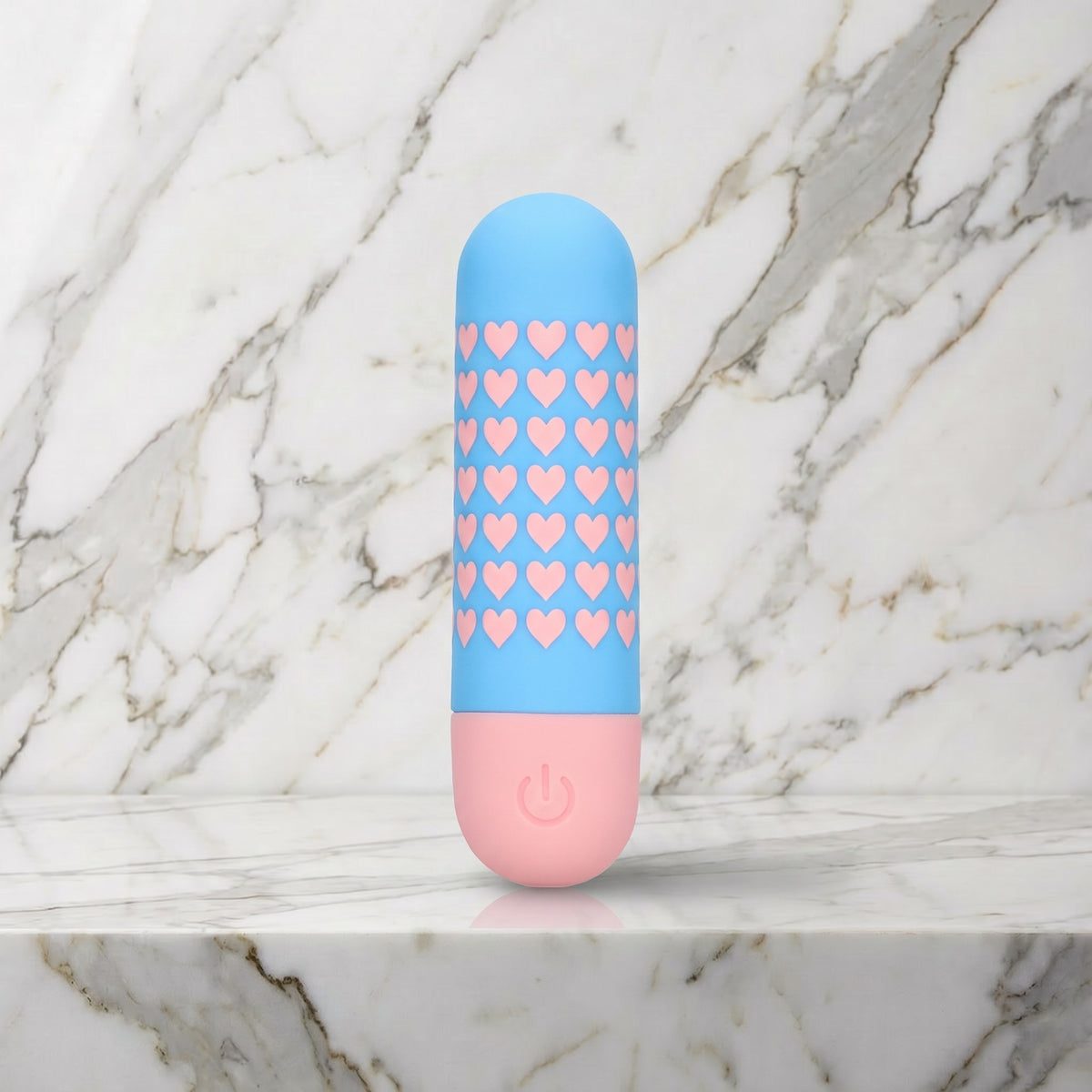 Lichtblauwe bullet vibrator met roze hartjes rechtop op een marmeren plank, Mini vibrator Heart